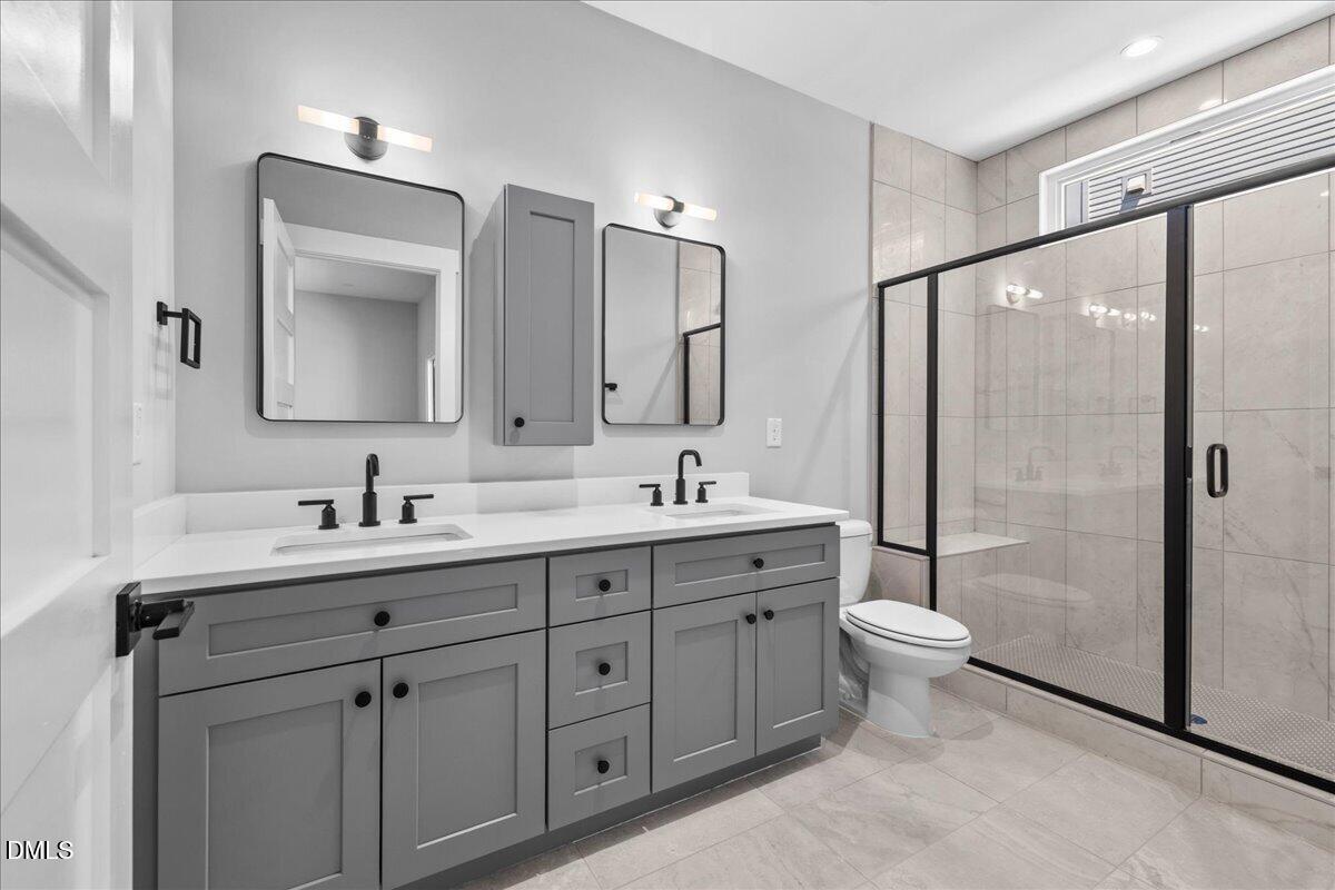 541 Bragg Street Raleigh, NC 27601 - Photo 23 of 44 a bathroom with a double vanity sink toilet mirror and shower