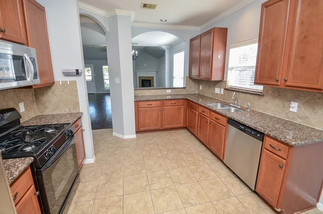 a kitchen with granite countertop stainless steel appliances and wooden cabinets