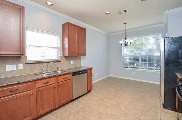 a kitchen with granite countertop a sink stove and cabinets