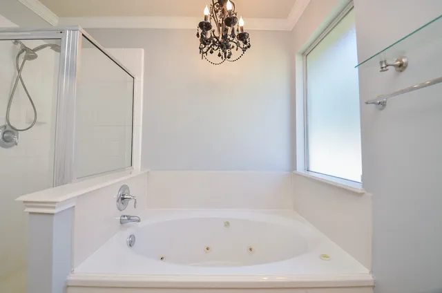 a bathroom with a tub sink and mirror