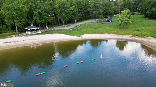 an aerial view of a house with a yard and lake view