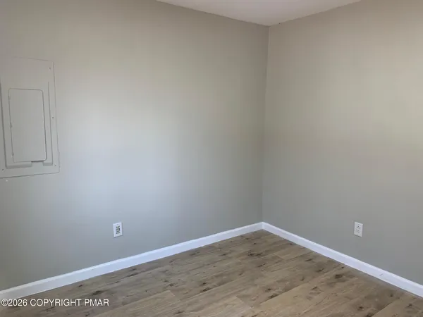a view of an empty room with wooden floor