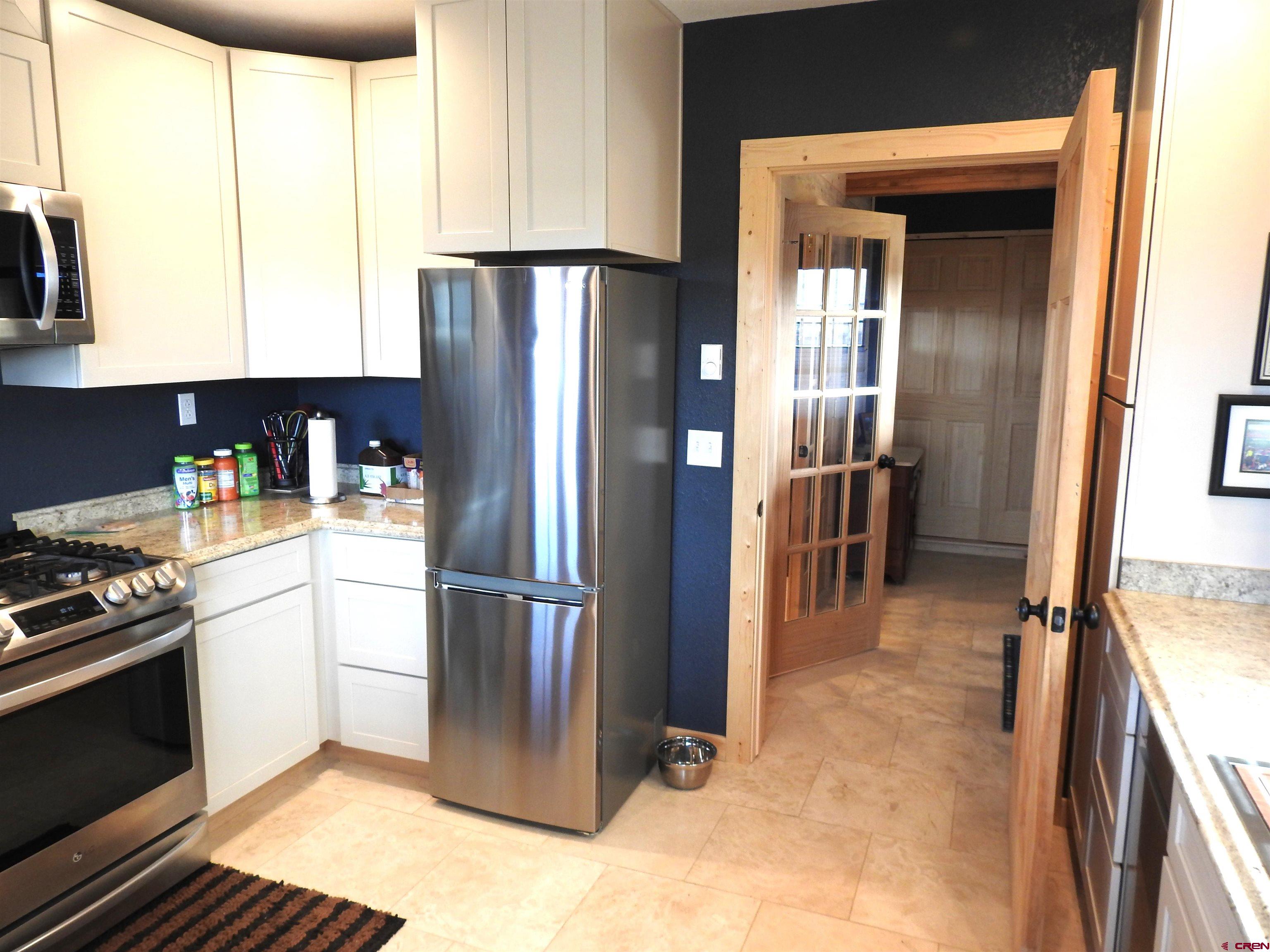 34099 Rd M Mancos, CO 81328 - Photo 15 of 37 a kitchen with stainless steel appliances granite countertop a refrigerator a stove and a sink with cabinets