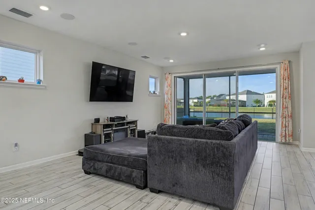 a kitchen with stainless steel appliances a dining table chairs refrigerator sink and cabinets