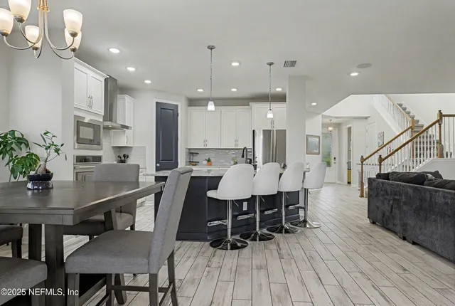 a kitchen with kitchen island granite countertop wooden floors and white cabinets