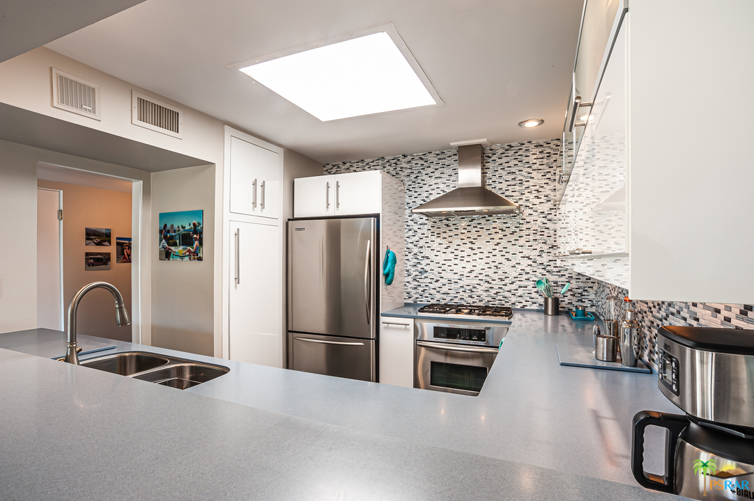 1805 Sandcliff Road Palm Springs, CA 92264 - Photo 21 of 51 a kitchen with kitchen island a counter top space a sink stainless steel appliances and cabinets