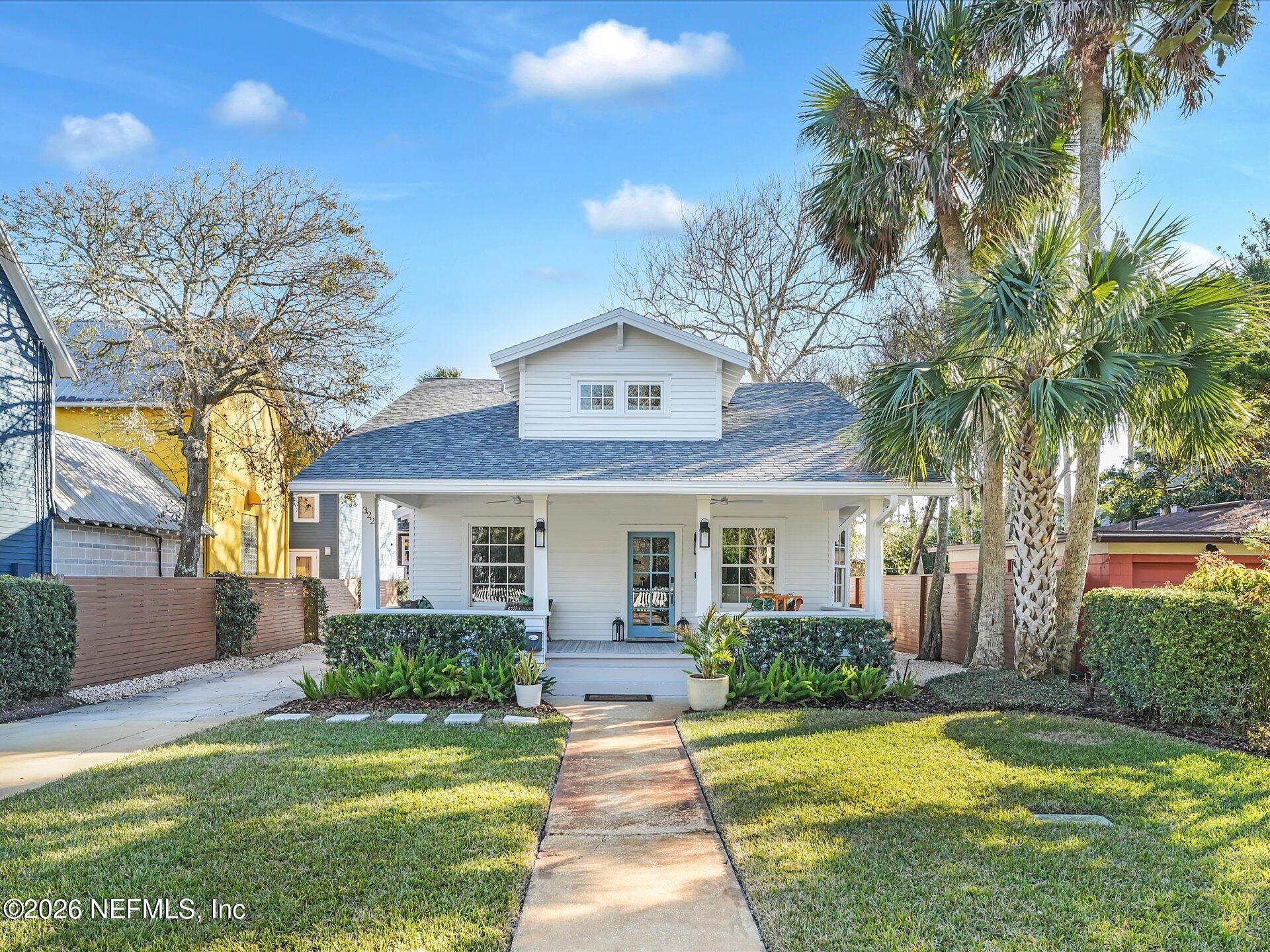 a front view of a house with a yard and potted plants