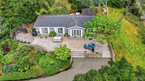 an aerial view of a house with a yard and sitting area