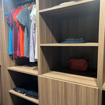 a view of walk in closet with clothes