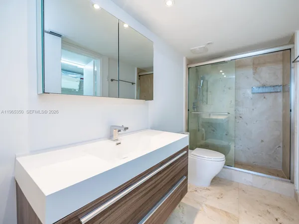 a bathroom with a sink a toilet and shower