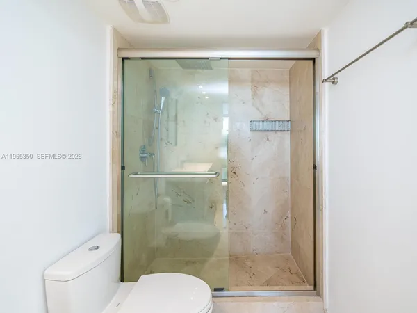 a bathroom with a shower a toilet and a sink