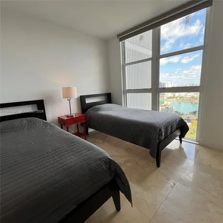 a bedroom with two beds and a large window