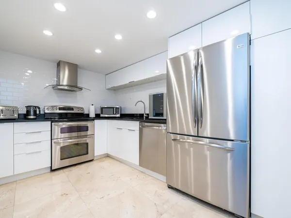 a kitchen with stainless steel appliances granite countertop a refrigerator and a stove top oven