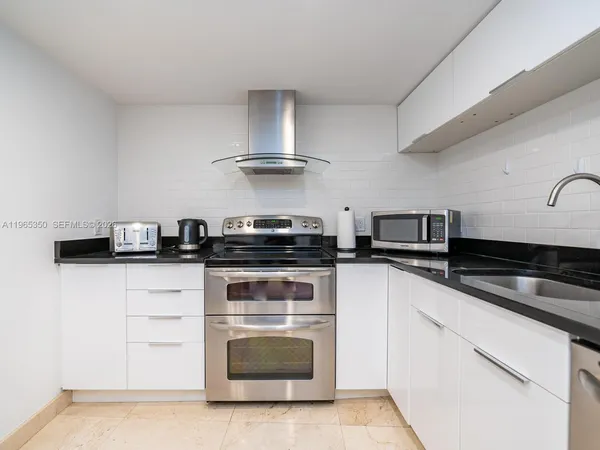 a kitchen with stainless steel appliances granite countertop a stove and a sink