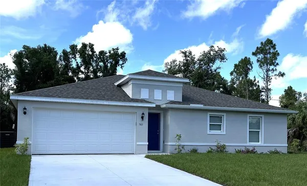 a front view of a house with a garden and plants