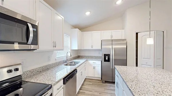 a kitchen with stainless steel appliances granite countertop a refrigerator stove and oven