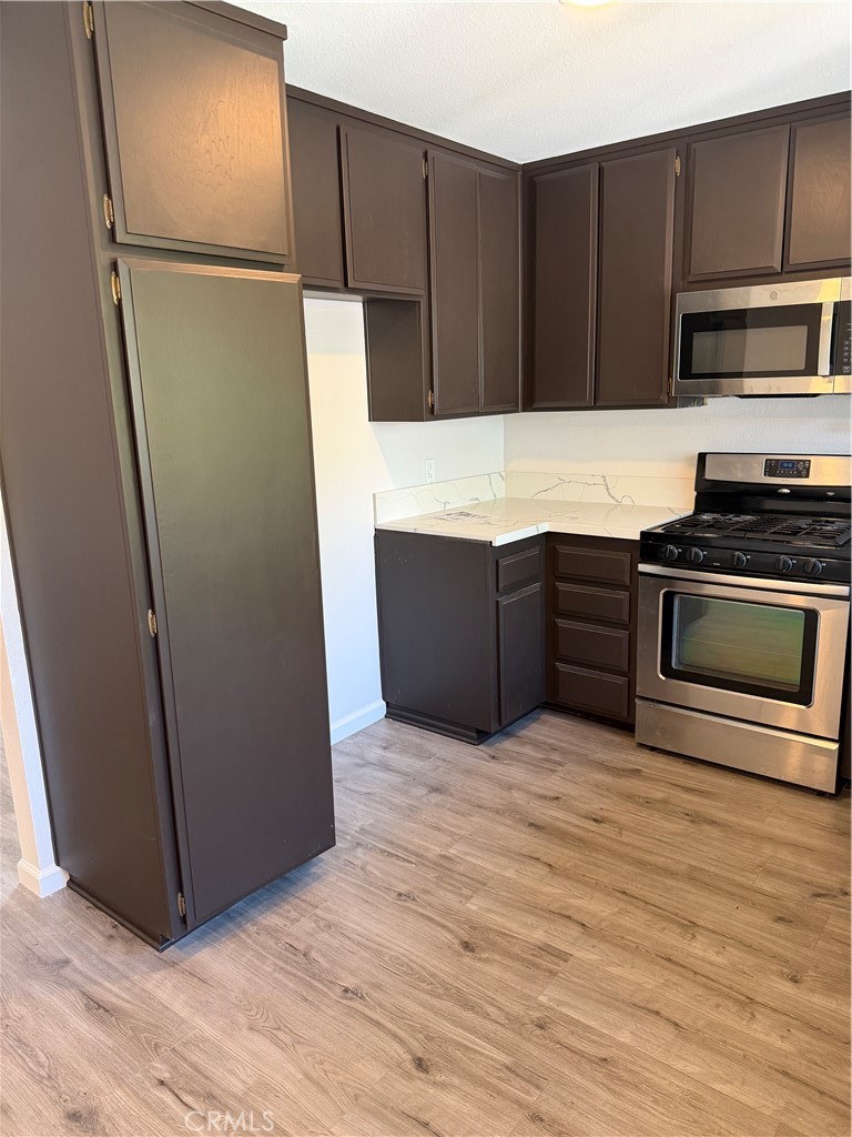 3458 Thunder Drive Oceanside, CA 92056 - Photo 4 of 13 a view of kitchen with stainless steel appliances wooden cabinets and wooden floor