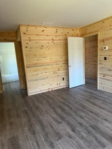 wooden view of walk in closet with empty racks