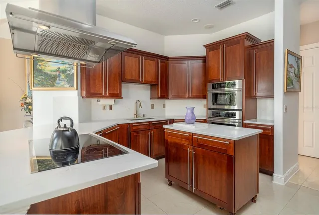 a kitchen with stainless steel appliances granite countertop a sink a stove and a refrigerator