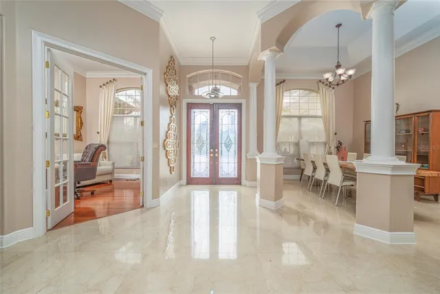 a living room with furniture a chandelier and a large window