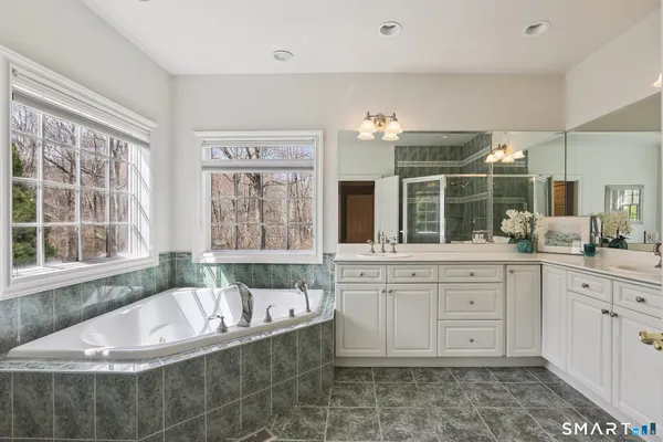 a spacious bathroom with a large tub sink and double vanity