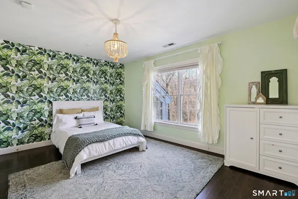 a bedroom with a bed window and dresser