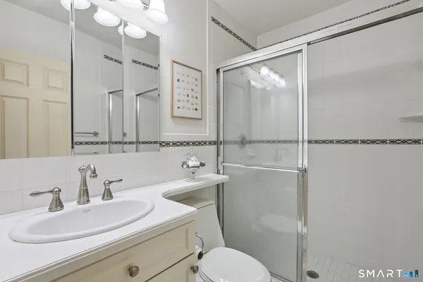 a bathroom with a sink toilet vanity and shower