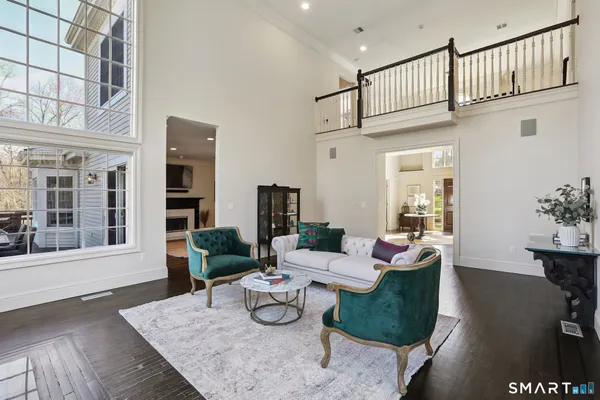 a living room with furniture wooden floor and a dining table