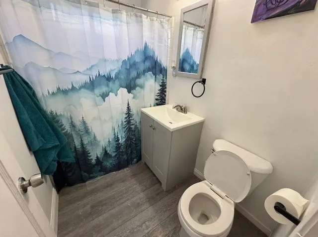 an empty room with wooden floor and cabinets