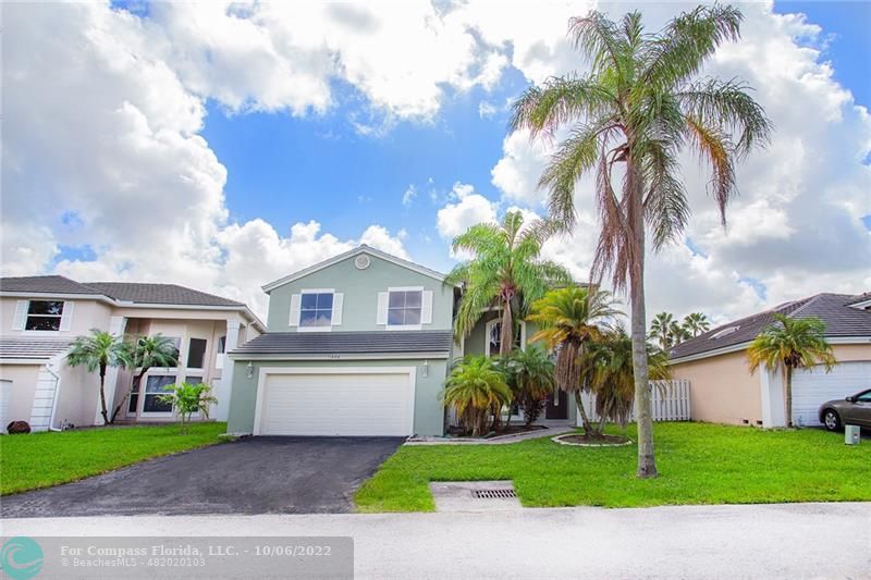 Winston Park Coconut Creek, FL 33073 - Photo 34 of 35 a front view of a house with a garden and a tree