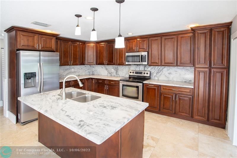 Winston Park Coconut Creek, FL 33073 - Photo 6 of 35 a kitchen with stainless steel appliances granite countertop a sink refrigerator and cabinets