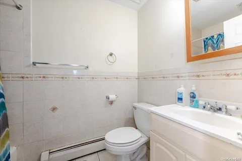 a bathroom with a granite countertop toilet and a sink