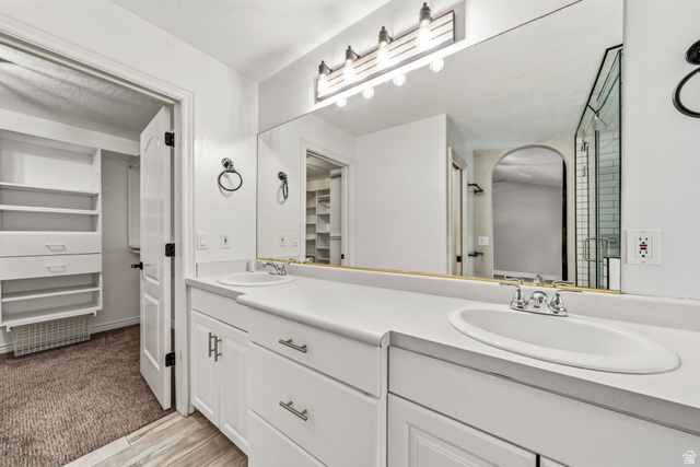 2154 Wasatch Boulevard Sandy, UT 84092 - Photo 20 of 32 Bathroom featuring dual white sinks with chrome fixtures, a full-width vanity mirror, and white cabinetry with brushed nickel hardware