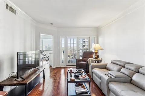 a living room with furniture a flat screen tv and a window