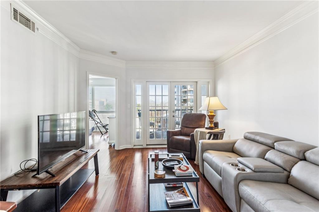 275 13th Street Northeast, Unit 707 Atlanta, GA 30309 - Photo 1 of 17 a living room with furniture a flat screen tv and a window