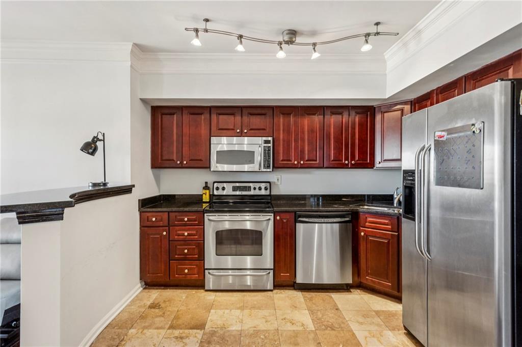 275 13th Street Northeast, Unit 707 Atlanta, GA 30309 - Photo 3 of 17 a kitchen with stainless steel appliances granite countertop a stove a refrigerator and a sink