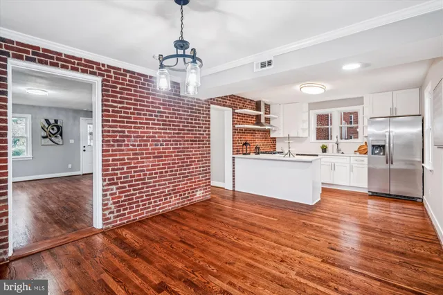 a view of kitchen with granite countertop cabinets and refrigerator