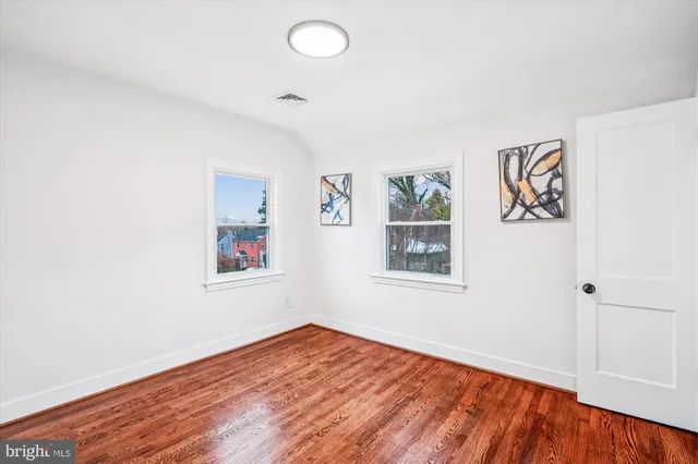 an empty room with a window and wooden floor