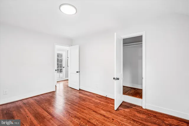 an empty room with wooden floor and entryway