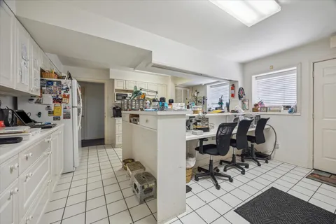 a kitchen with a dining table chairs and white appliances