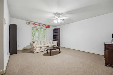 a living room with furniture and a ceiling fan