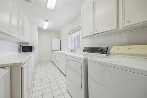a utility room with cabinets washer and dryer