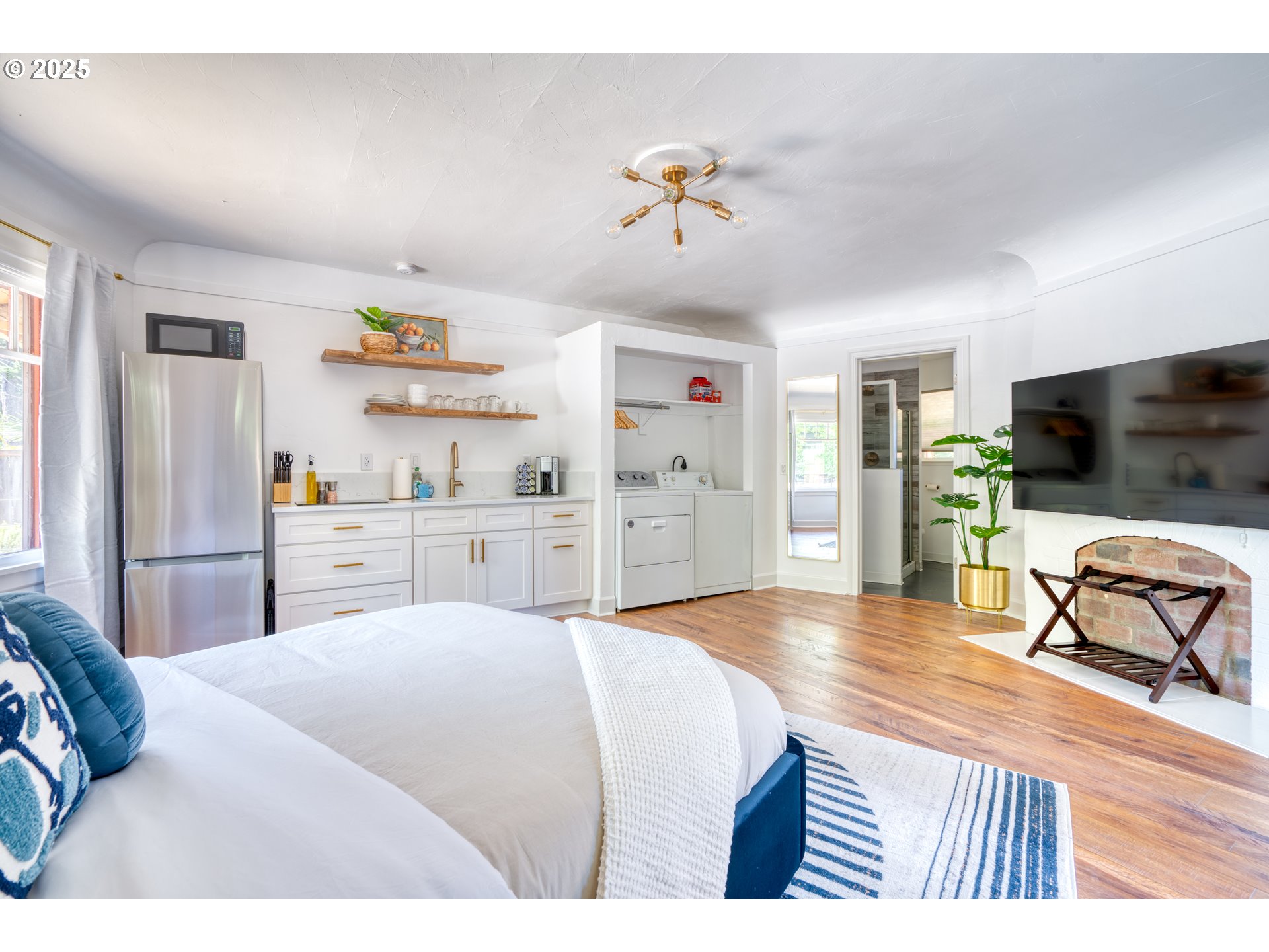 9647 Southwest Capitol Highway Portland, OR 97219 - Photo 11 of 33 a bedroom with a bed and a flat screen tv
