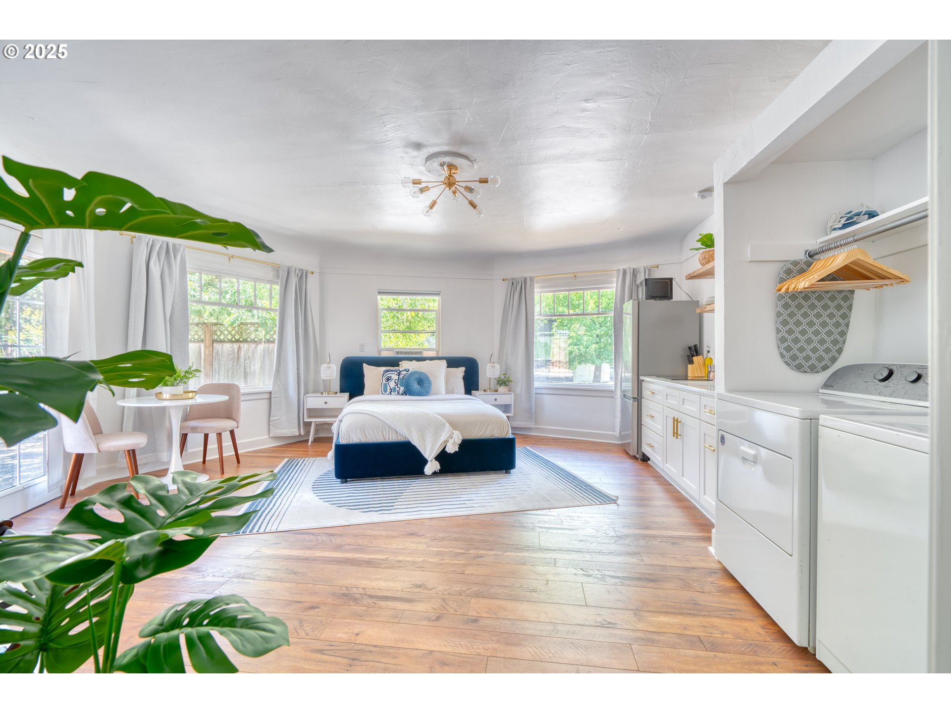 9647 Southwest Capitol Highway Portland, OR 97219 - Photo 12 of 33 a bedroom with a bed and a chandelier