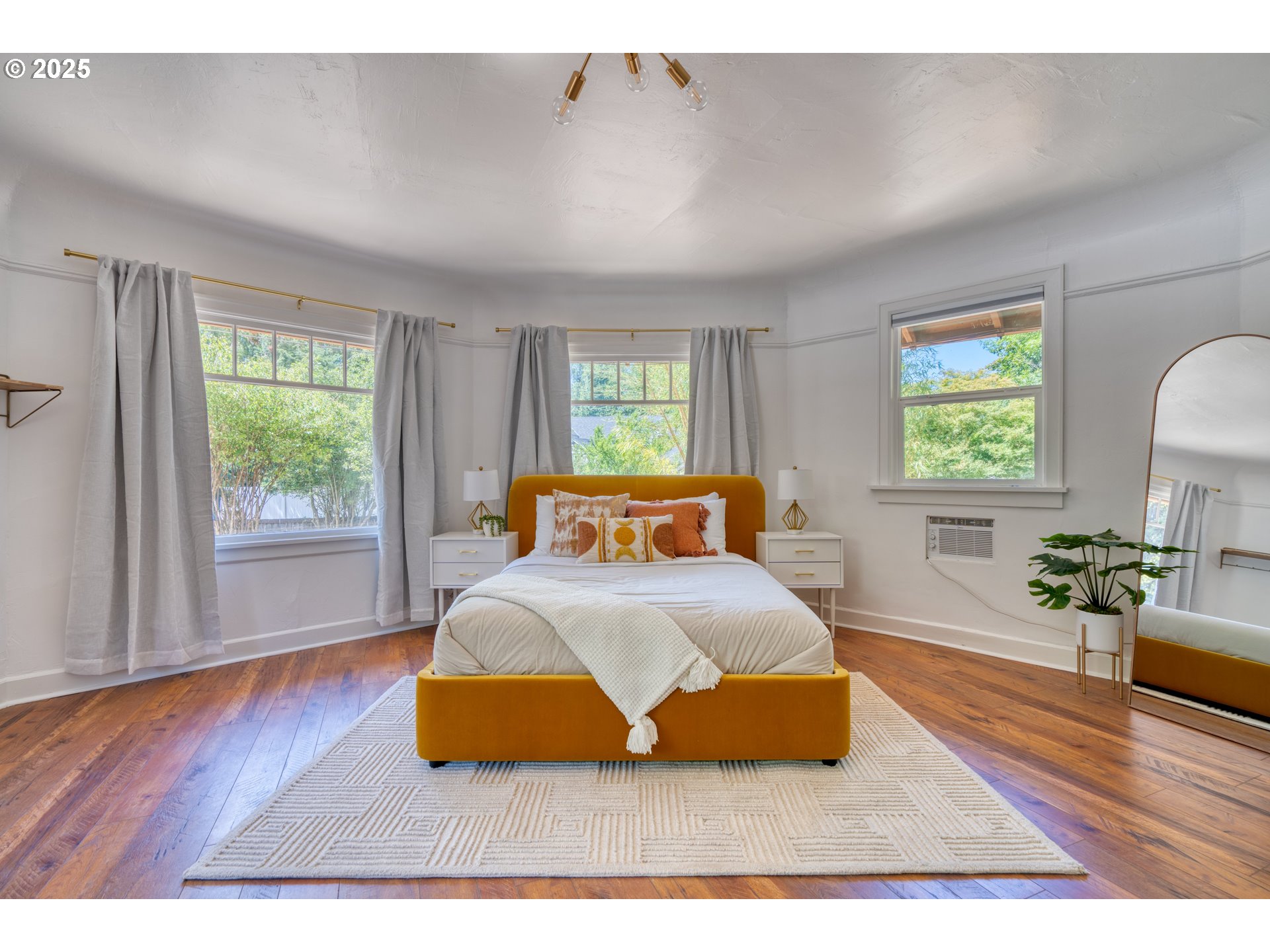 9647 Southwest Capitol Highway Portland, OR 97219 - Photo 23 of 33 a bedroom with a bed windows and wooden floor