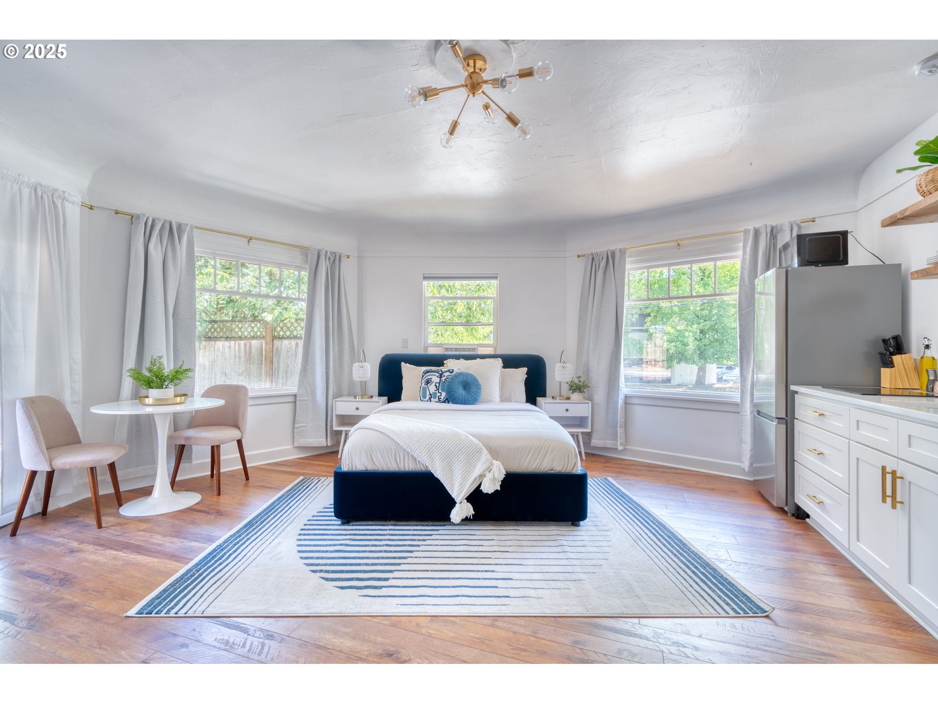 9647 Southwest Capitol Highway Portland, OR 97219 - Photo 7 of 33 a spacious bedroom with a large bed and a wooden floor
