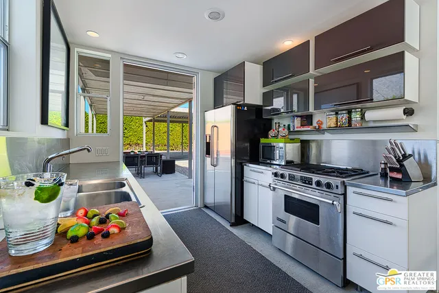 a kitchen with stainless steel appliances granite countertop sink stove and refrigerator