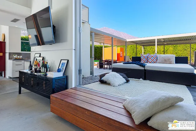 a living room with patio furniture and a potted plant