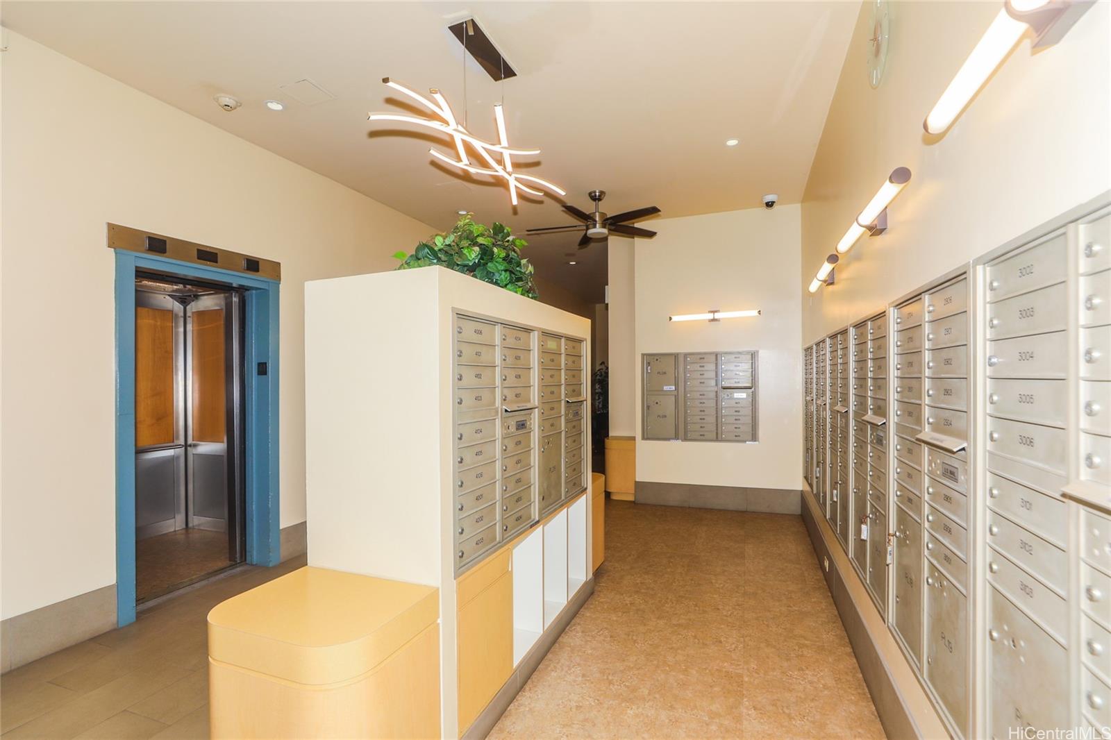 2525 Date Street, Unit 2303 Honolulu, HI 96826 - Photo 15 of 25 a view of hallway with stairs and a chandelier
