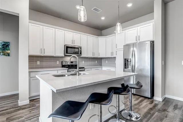 a kitchen with a sink a microwave a refrigerator and cabinets